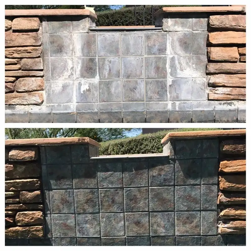 A slate tile spillway set into stacked-stone pillars, crusted grey with scale and then dark and clean